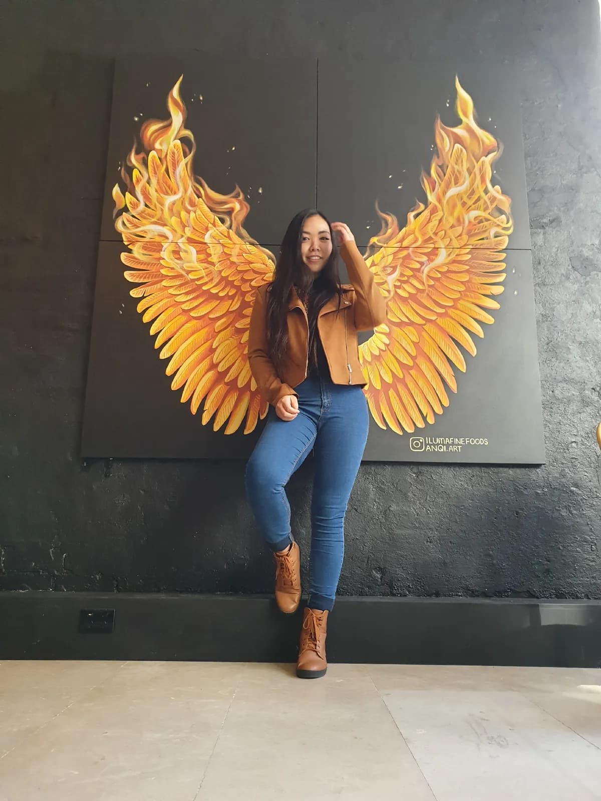Anqi with her golden wings mural